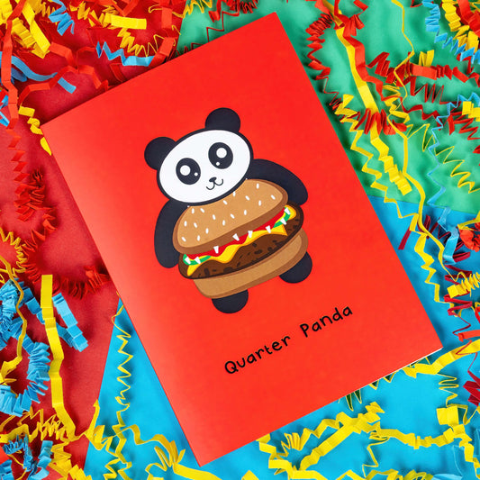 The Quarter Panda Burger Card on a red, blue and green background with yellow, red and blue crinkle card confetti. The red a6 greeting card has a smiling panda with its body being a seeded bun burger. Underneath in black reads 'quarter panda'.