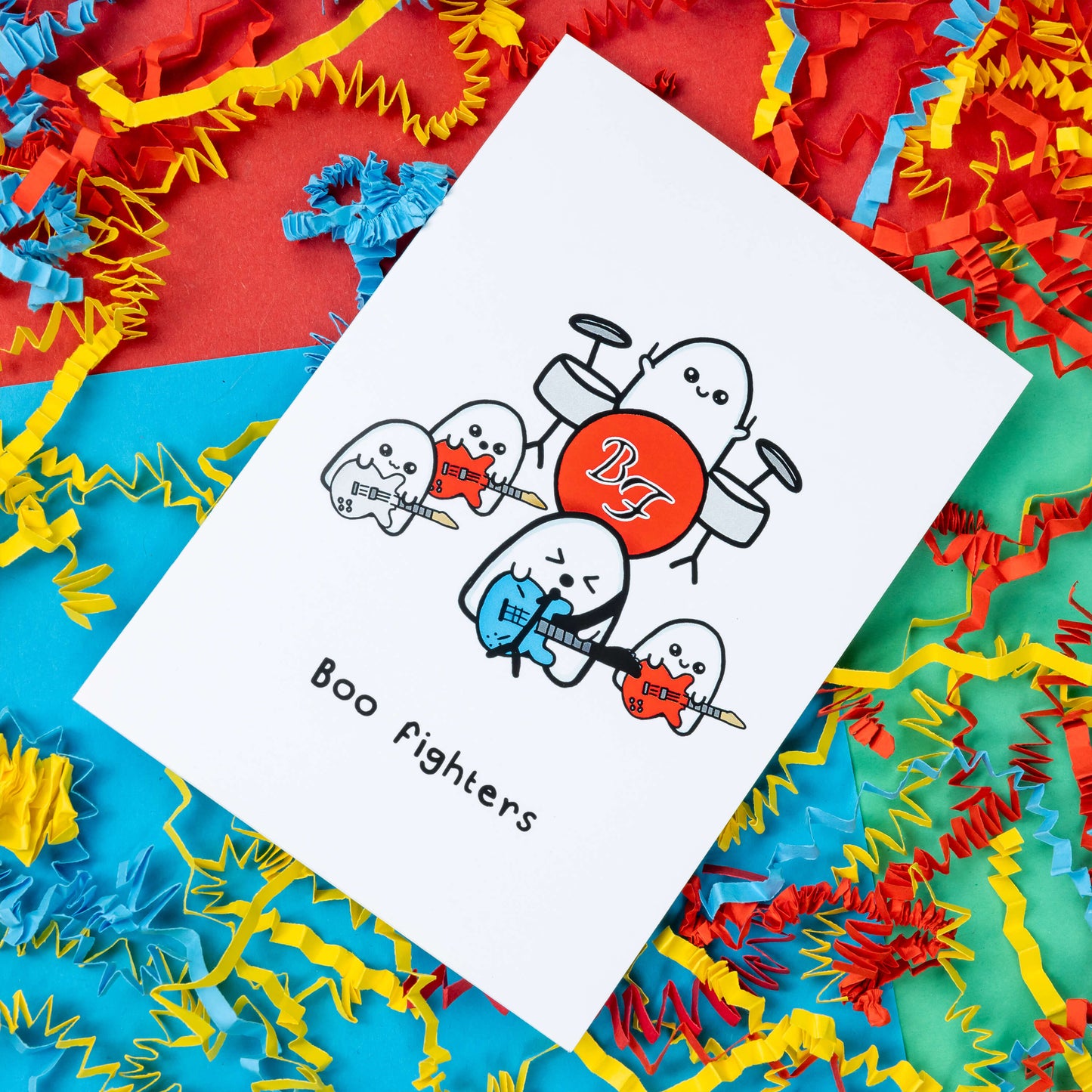 Boo Fighters Birthday Card on a green, blue and red background with red, blue and yellow crinkle confetti card. A white card with a kawaii ghost band playing blue, white and red guitars and a red Boo Fighters drum kit, underneath reads Boo Fighters in black text.