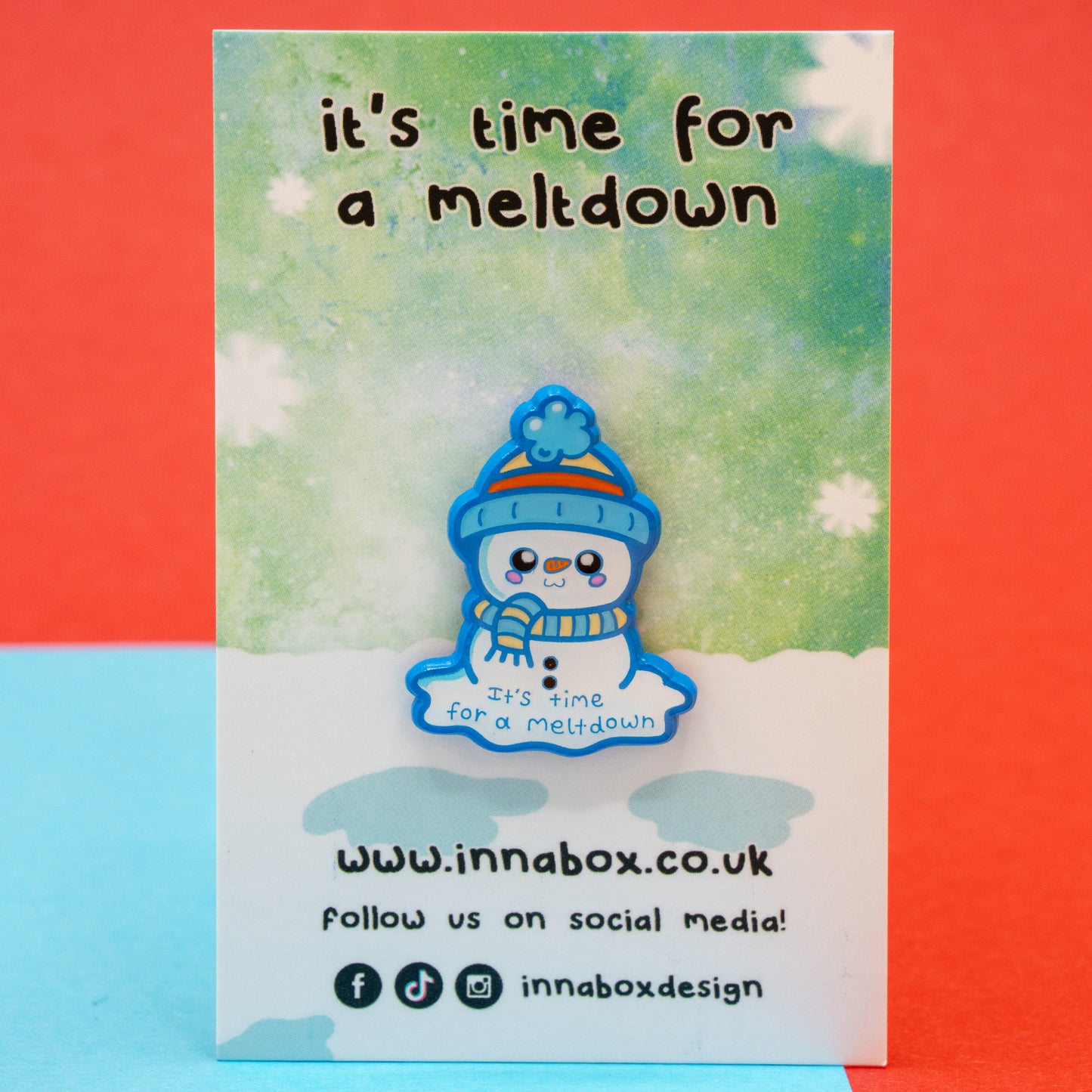 The Innabox ‘It’s Time For A Meltdown’ Snowman Enamel Pin shown sealed in protective packaging on its snowy backing card. Featuring a sweet snowman with a hat and scarf, this disability inspired enamel pin offers gentle encouragement for those facing chronic illness or mental health struggles.