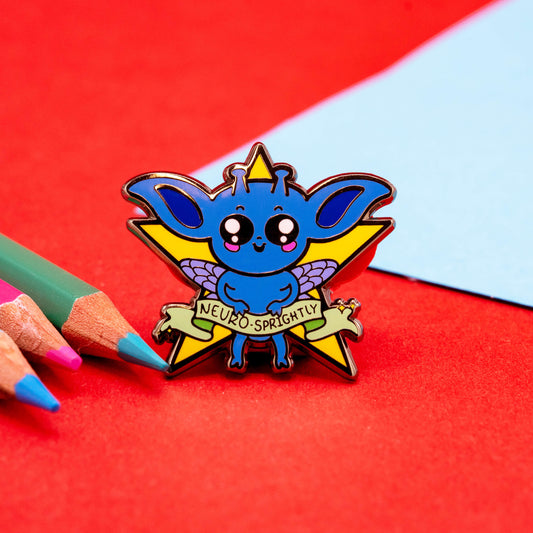Close-up of the Neuro-Sprightly enamel pin by Innabox, featuring a blue fantasy creature with sparkly wings and a star background. The banner reads “Neuro-Sprightly.” A cheerful disability-inspired design celebrating neurodiversity.