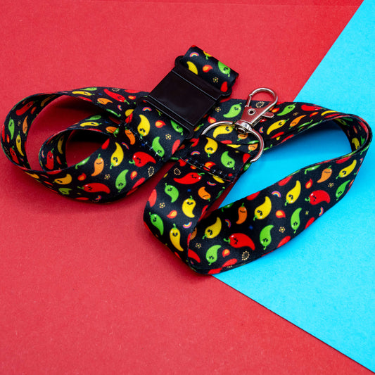 The Neuro-Spicy Lanyard by Innabox displayed in a looped arrangement on red and blue card. Features a rainbow chilli print, black safety clasp, and silver metal dog clip, designed to brighten up your daily essentials.
