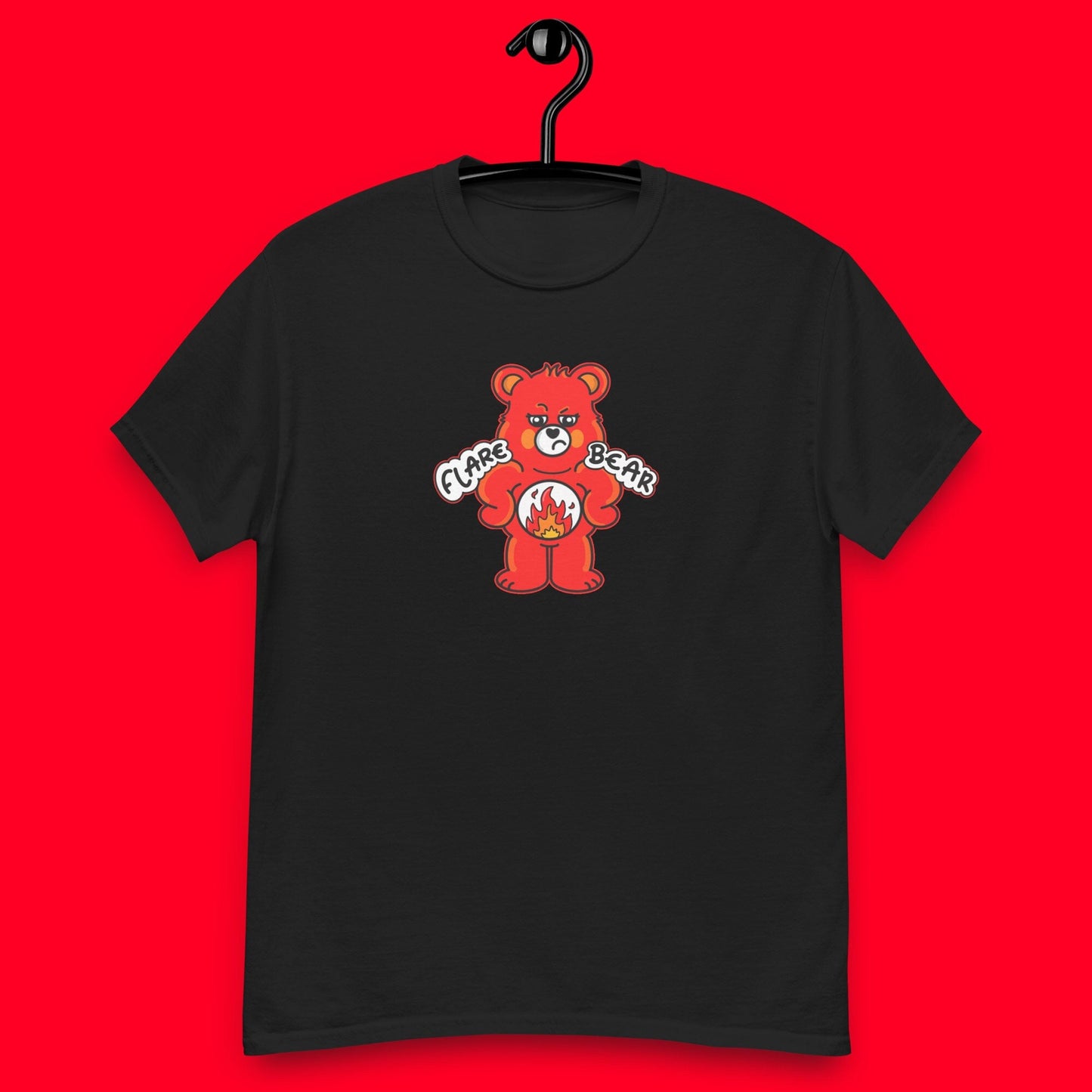 Flare Bear T-shirt hanging on a red background. The black short sleeve tshirt is of a red bear with a fed up expression and hands on its hips. There is a white circle on its belly with flames inside. Flare Bear is written on the middle. The tshirt is designed to raise awareness for chronic illness flare ups.