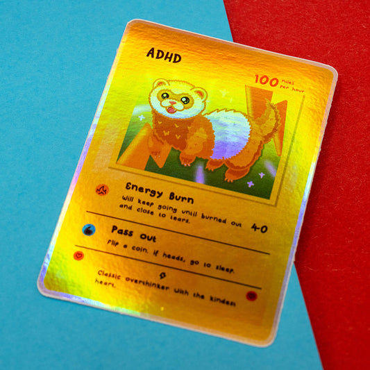 A holographic version of the Innabox Neurodivergent Collectable Trading Card Sticker – ADHD, showing a shiny rainbow sheen across the ferret character illustration. The card highlights traits such as Energy Burn and Pass Out. Photographed on a fun blue and red background, ideal for fans of uplifting disability-inspired stationery and collectables.