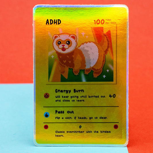 A bright close-up of the Innabox Neurodivergent Collectable Trading Card Sticker – ADHD, featuring a cute ferret character with energetic, playful artwork. The card lists traits like Energy Burn and Pass Out. Displayed against a blue and red backdrop, this disability-inspired sticker is perfect for neurodivergent collectors and stationery lovers.