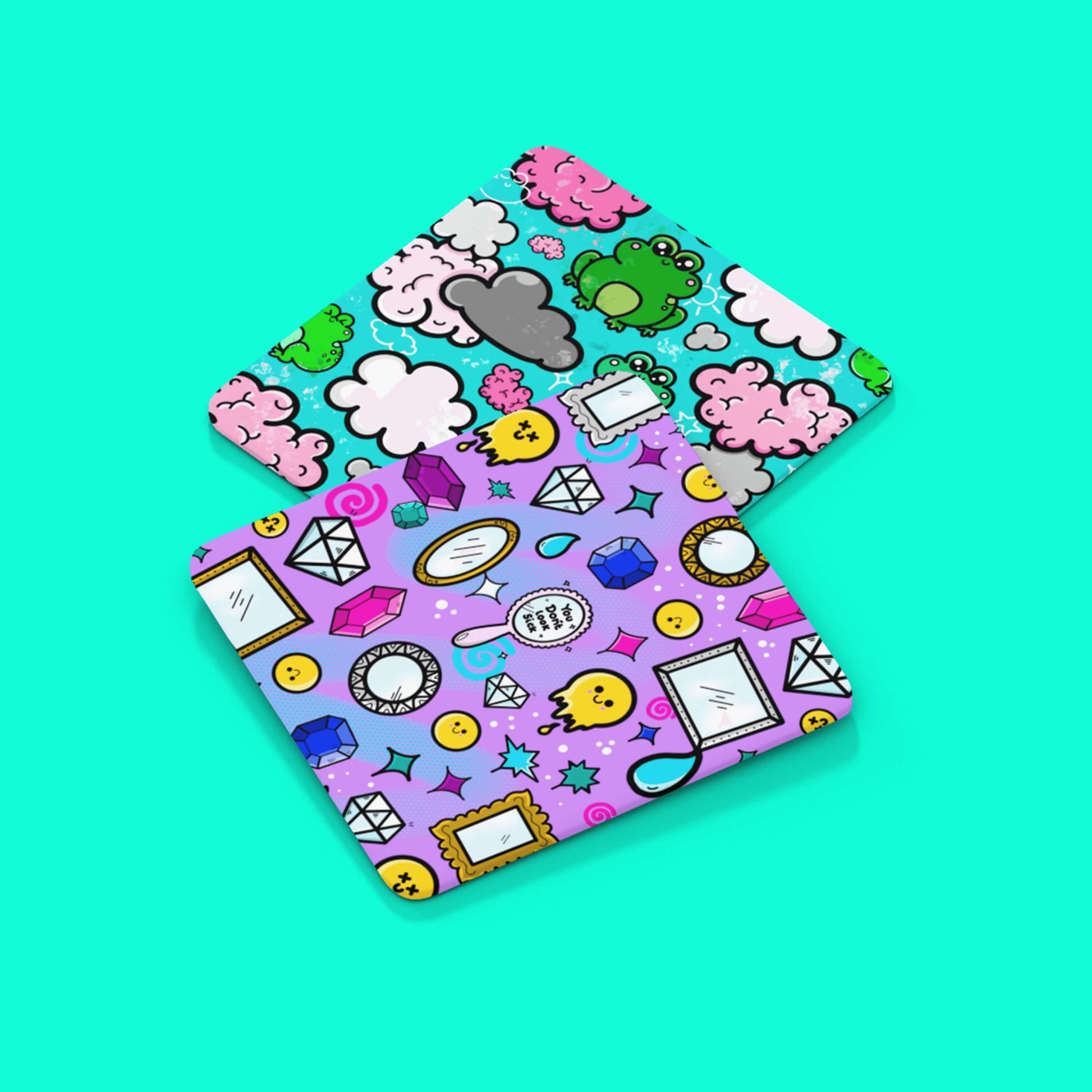 Brain Frog Coaster - Brain Fog on a blue background with the You Don't Look Sick Coaster. The wooden coaster features happy kawaii face green frogs with pink brain style, grey & white clouds with white sparkles on a blue background. The design was created to raise awareness for brain fog. The You Don't Look Sick coaster features mirrors, gems and melting smiley faces on a purple background.