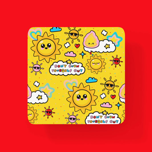 The Dont burn yourself out coaster on a red background. A yellow wooden coaster with cute sun, cloud, star and heart illustrations. 'Don't burn yourself out' is written in coloured letters in white clouds around the coaster. Inspired by the self care movement.