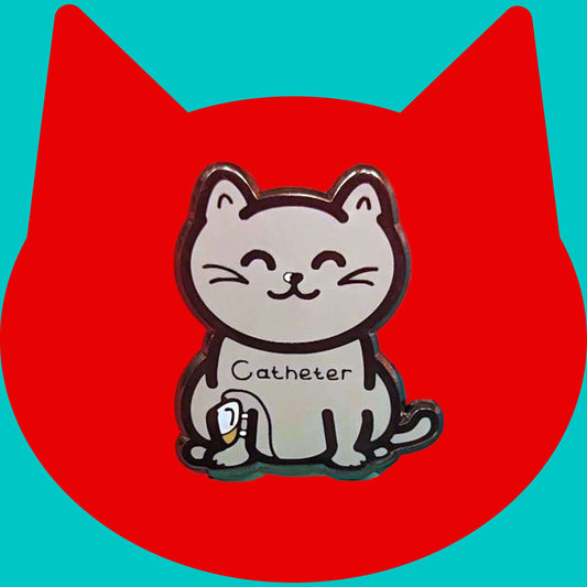 The Catheter Enamel Pin - Catheter on a red and blue background. The pin is a grey smiling cat sat down with a urine drainage Urostomy pouch strapped to its right leg and text across its chest reading 'catheter'. The pin is designed to raise awareness for bladder problems such as UTIs and other chronic illnesses.