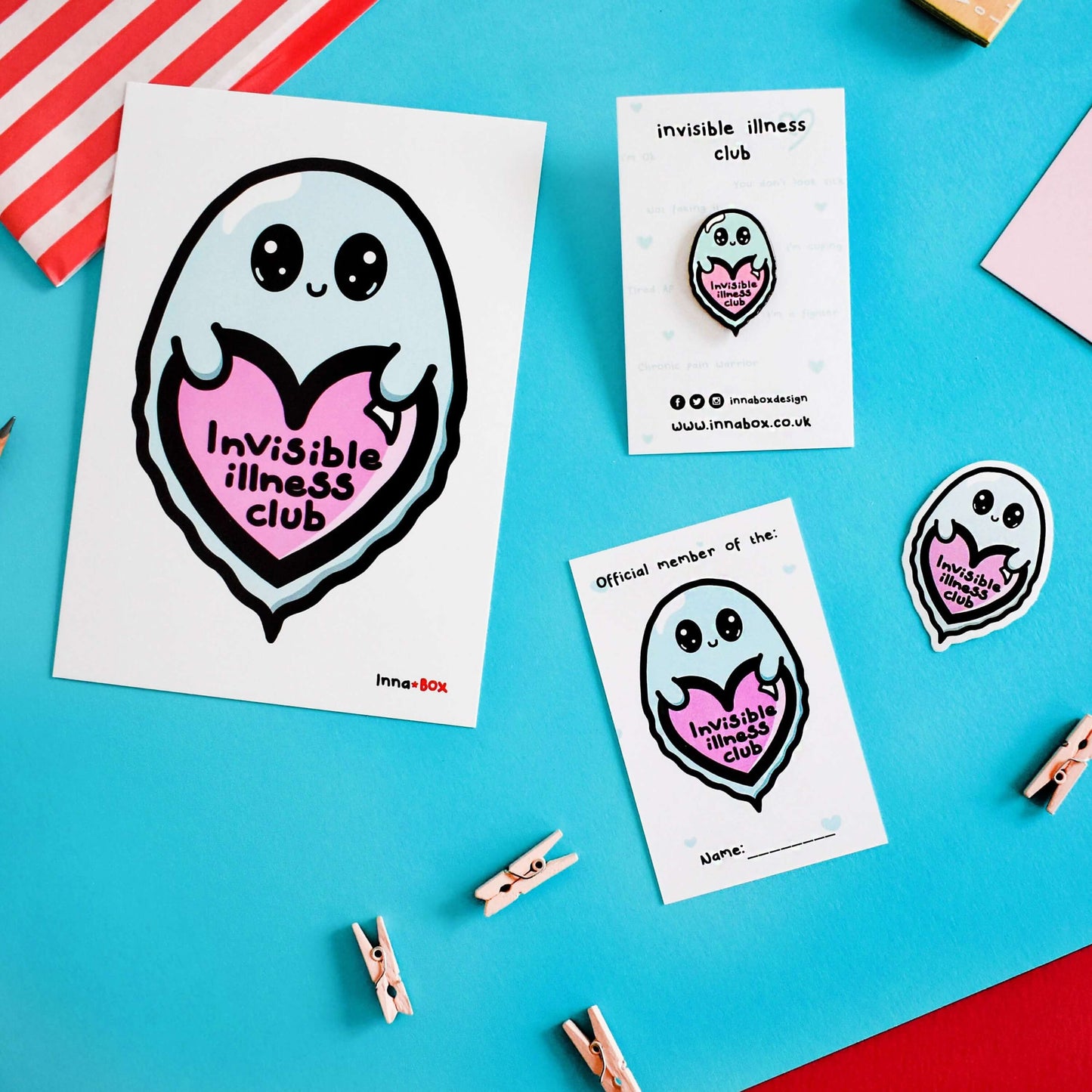 Part of the Invisible Illness Club Bundle, featuring Invisible illness club postcard, Invisible illness club sticker, Invisible illness club enamel pin and Invisible illness club membership card on a blue background. Each item features a cute mint green ghost with big eyes and little smile holding a pink heart with it's little hands that has 'invisible illness club' written in black writing in the middle of the heart.