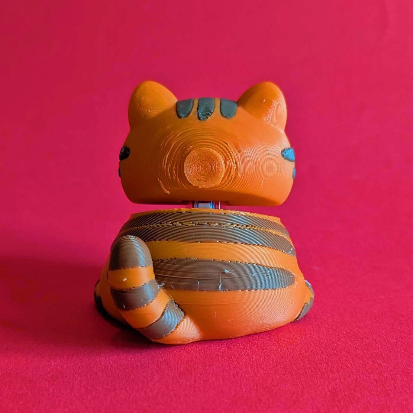 Back view of Neurodiverse Kitty Desk Buddy by Innabox highlighting striped detailing, tail and visible 3D printed finish. Small batch sensory fidget toy made from biodegradable PLA, designed as a comforting desk companion for people with autism, chronic illness, anxiety and hidden disabilities.