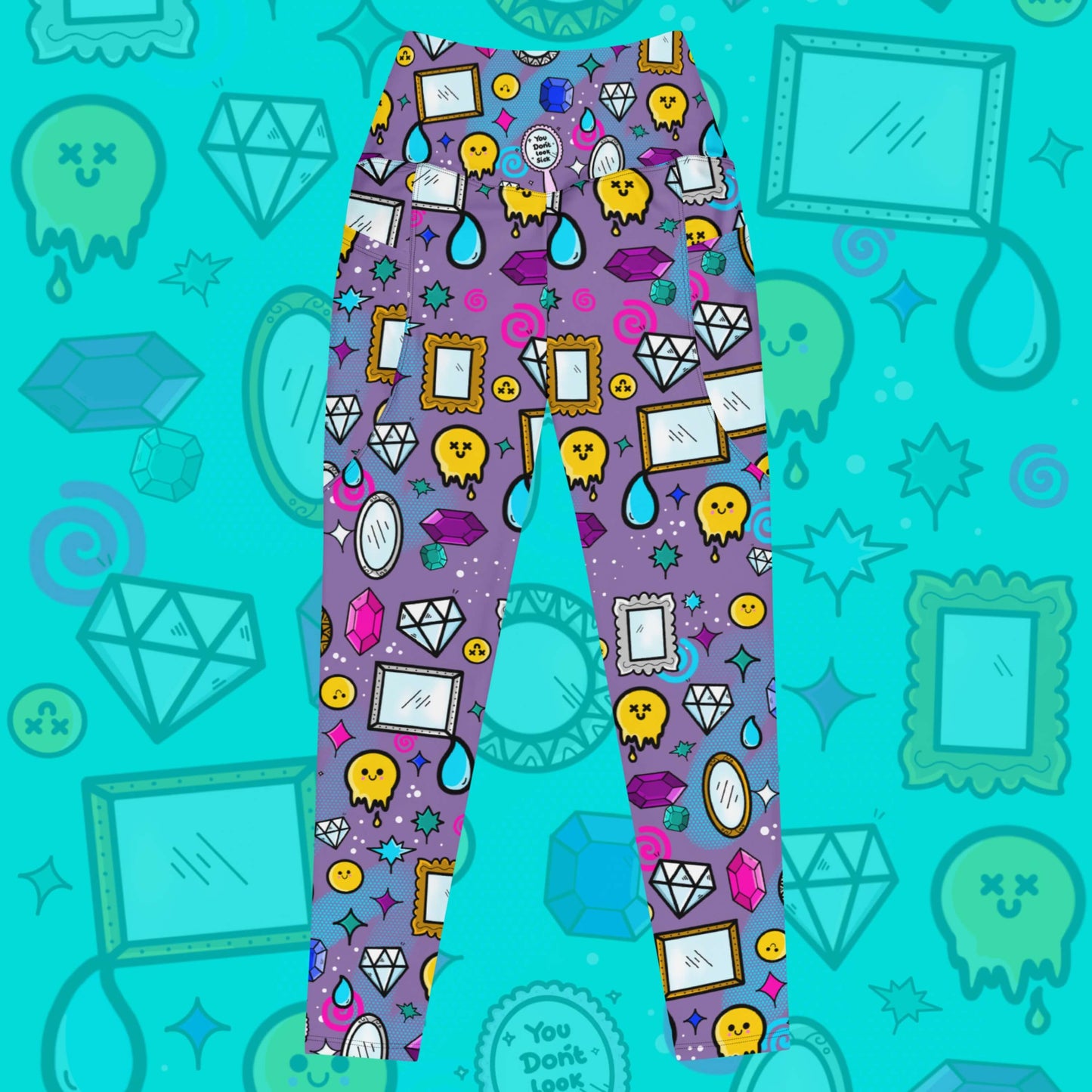 The You Don't Look Sick Leggings with pockets on a blue background with a faded version of the print. The purple base leggings features melting yellow smiley faces, mirrors, gemstones, teardrops, sparkles, swirls and dots with a centre hand held mirror reading 'you don't look sick'. The hand drawn design is raising awareness for invisible illnesses.