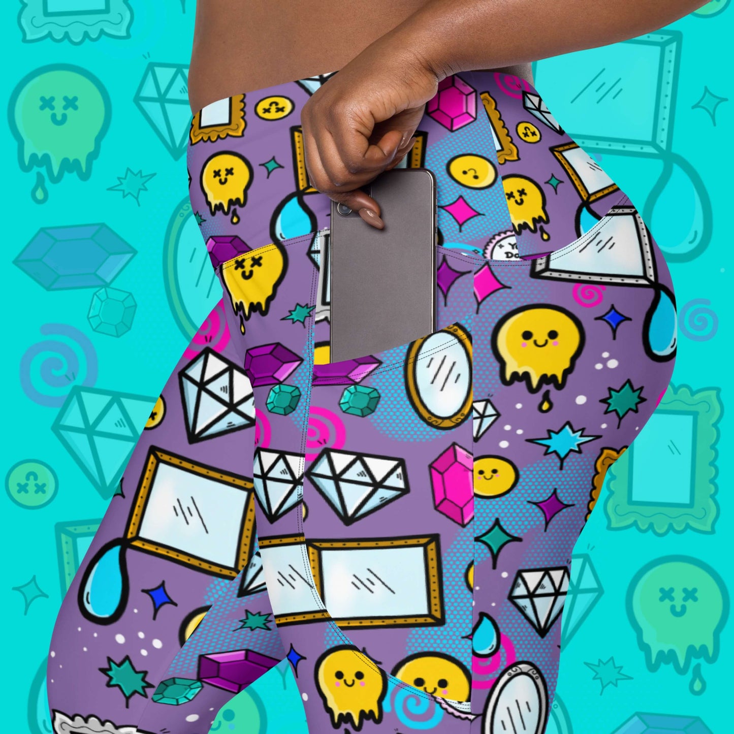The You Don't Look Sick Leggings with pockets modelled on a blue background with a faded version of the print, the model is popping a grey phone into the legging pocket. The purple base leggings features melting yellow smiley faces, mirrors, gemstones, teardrops, sparkles, swirls and dots with a centre hand held mirror reading 'you don't look sick'. The hand drawn design is raising awareness for invisible illnesses.