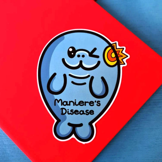 The Maniere's Disease Manatee Sticker - Ménière's Disease on a red and blue background. The blue winking manatee sticker has a red and yellow inflamed ear with black text across its body reading 'maniere's disease'. The hand drawn design is raising awareness for Ménière's Disease and vertigo.