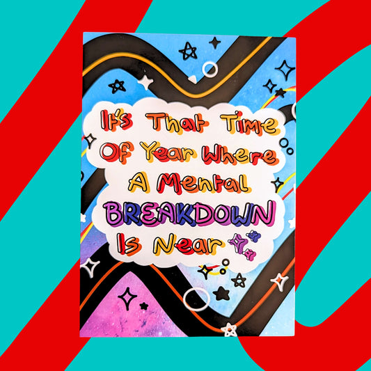 The Mental Breakdown is Near Postcard on a red and blue background. The blue and purple galaxy background card features black, yellow, orange and red squiggle lines, black and white sparkles with a white centre cloud with rainbow text reading 'it's that time of year where a mental breakdown is near'. 