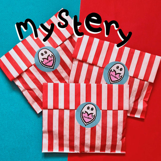 The Mystery Enamel Pin Bag set of three on a red and blue background. Three red and white stripe candy bags sealed with the innabox blue ghost logo sticker with black text at the top reading 'mystery'. A surprise goodie bag full of three enamel pins raising awareness for hidden disabilities and invisible illnesses.