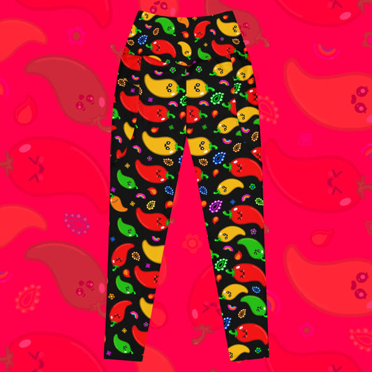 Black leggings with pockets with red, green, orange and yellow chilli peppers with cute faces on and various cute doodles around them  The background of the photo is a faded close up of the print. The hand drawn design is raising awareness for neurodiversity. 