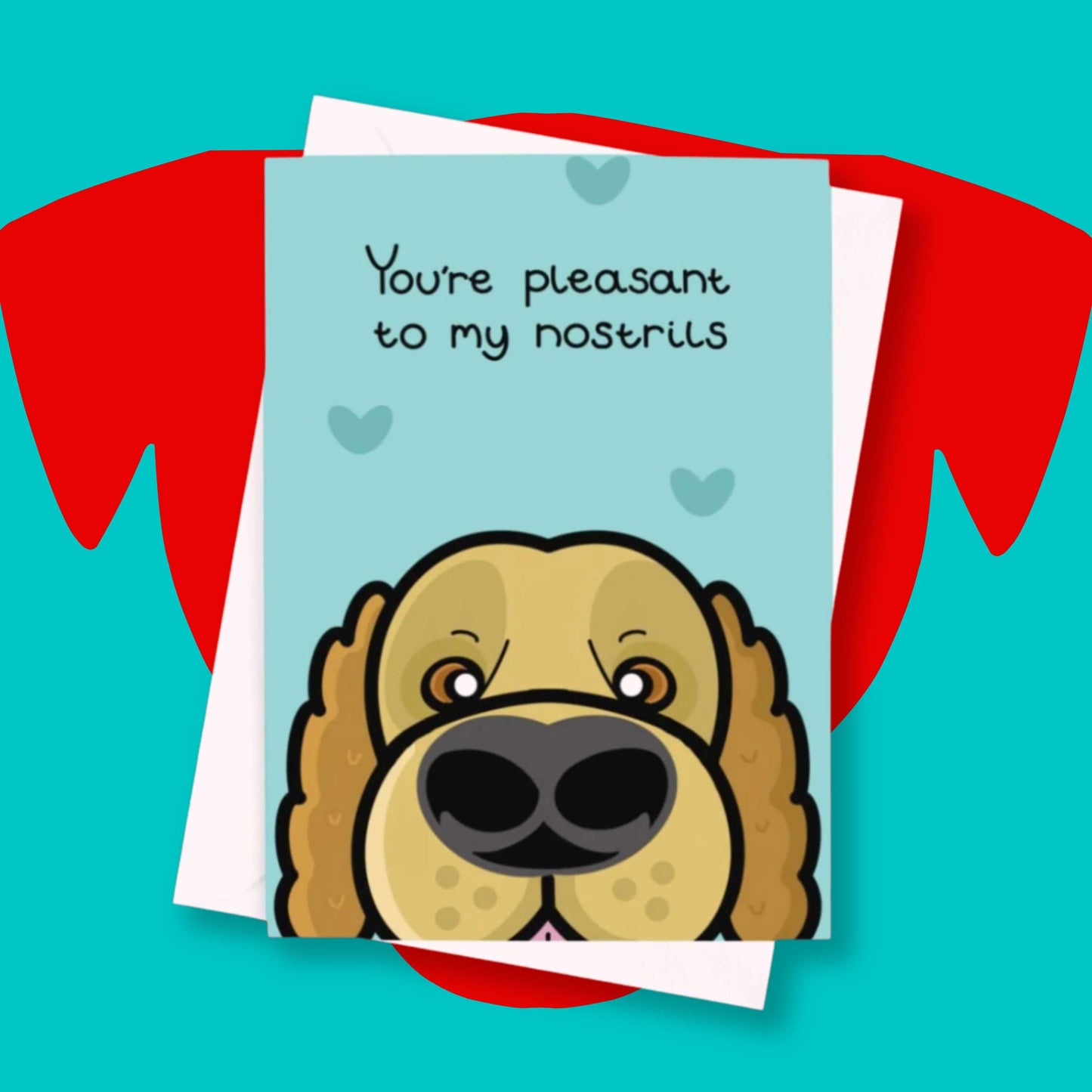 You're Pleasant To My Nostrils Dog Card on a red and blue background. The blue card has darker blue love hearts and a close up of a dog's face at the bottom looking like it is sniffing. There is black text at the top of the card that reads 'you're pleasant to my nostrils'.