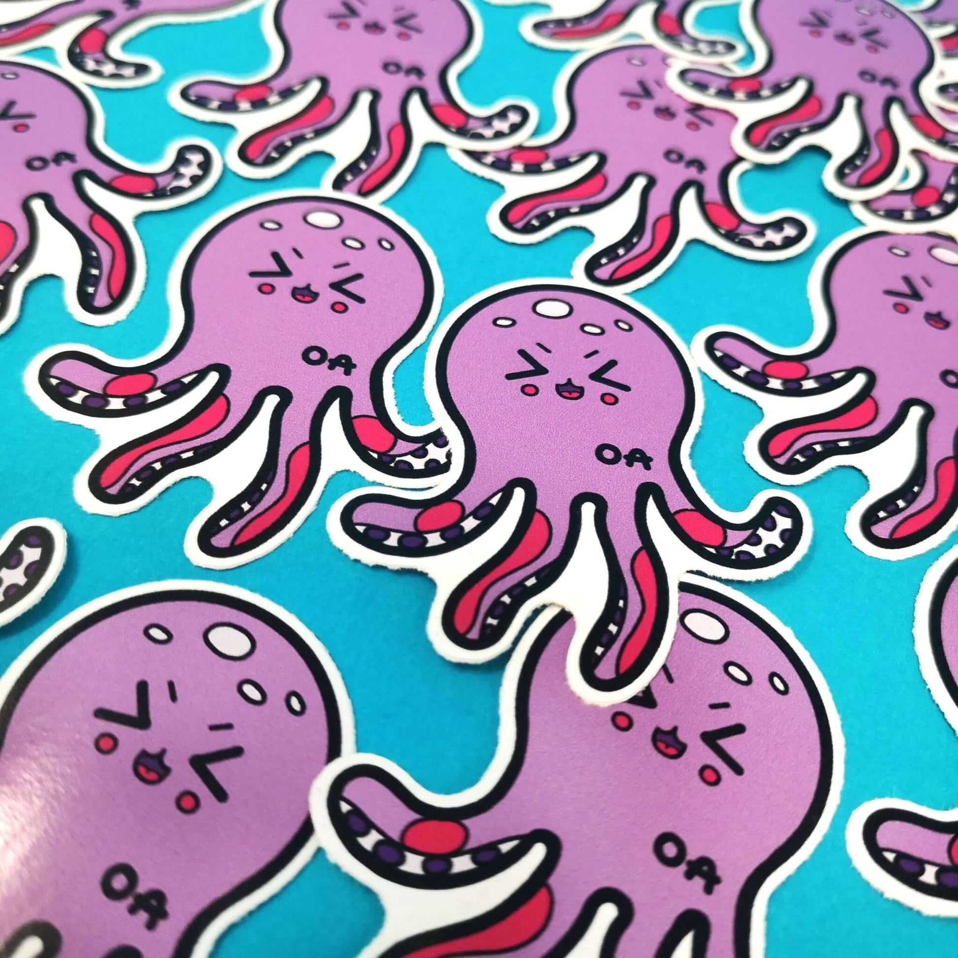 The Octeoarthritis Octopus Sticker - Osteoarthritis on a blue background with multiple copies of the same sticker. The purple smiling octopus has red patches all over its tentacles with the black intials 'OA' on its body. The hand drawn design is raising awareness for Osteoarthritis.