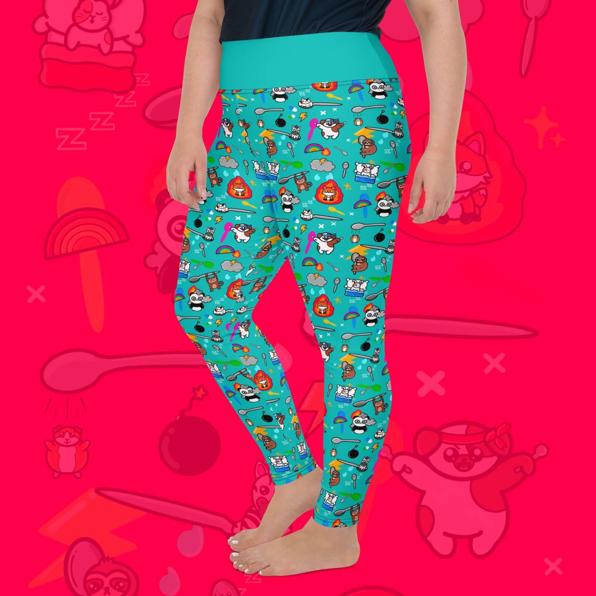The Spoonie Plus Size Leggings modelled on a red background with a faded version of the print in the background. The blue leggings feature various invisible illness themed animals, rainbows, spoons, sparkles, flames, pills and lightning bolts. Raising awareness for hidden disabilities.
