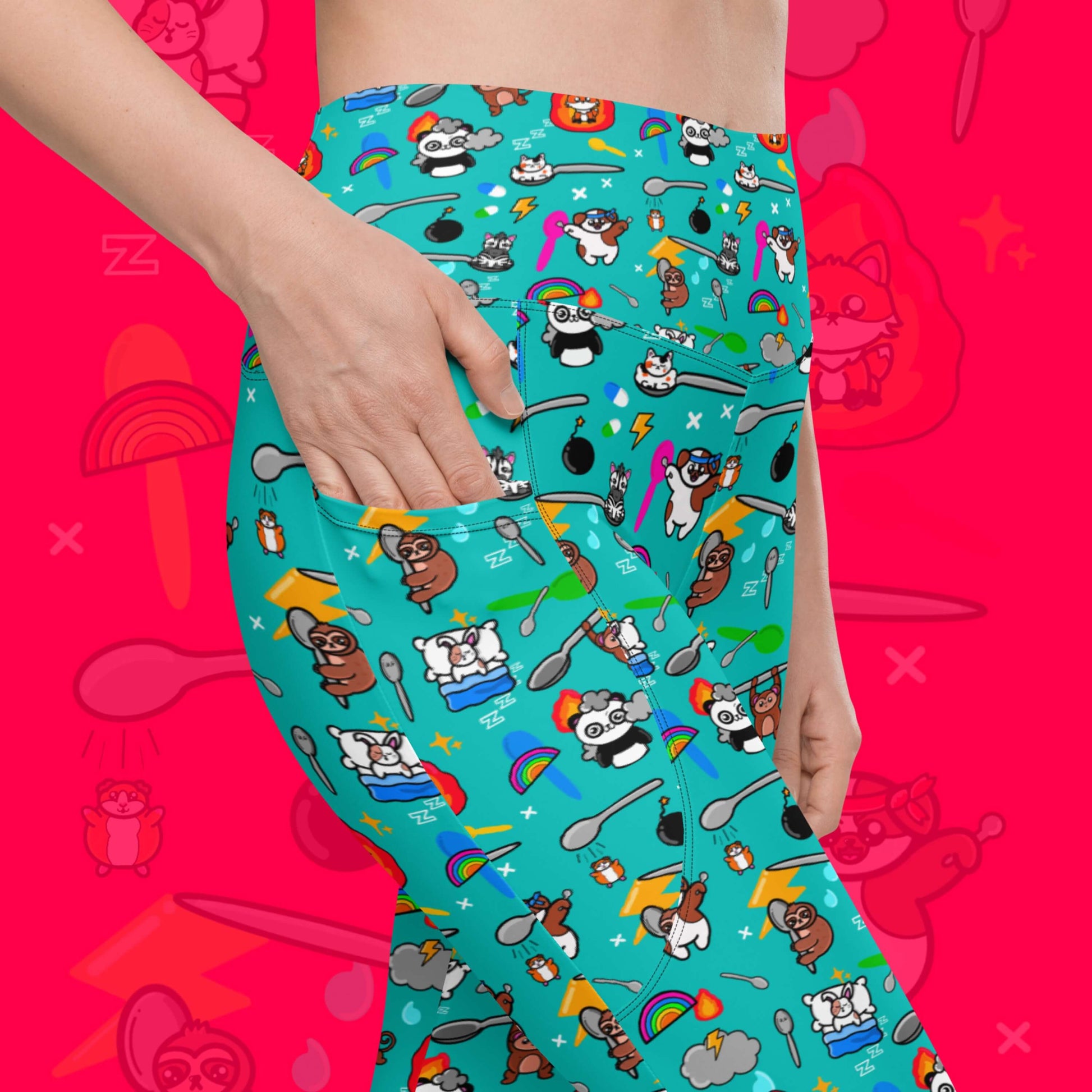 The Spoonie Leggings with Pockets modelled by a femme person putting their hand in the pocket on a red background with a faded version of the print in the background. The blue leggings feature various invisible illness themed animals, rainbows, spoons, sparkles, flames, pills and lightning bolts. Raising awareness for hidden disabilities.