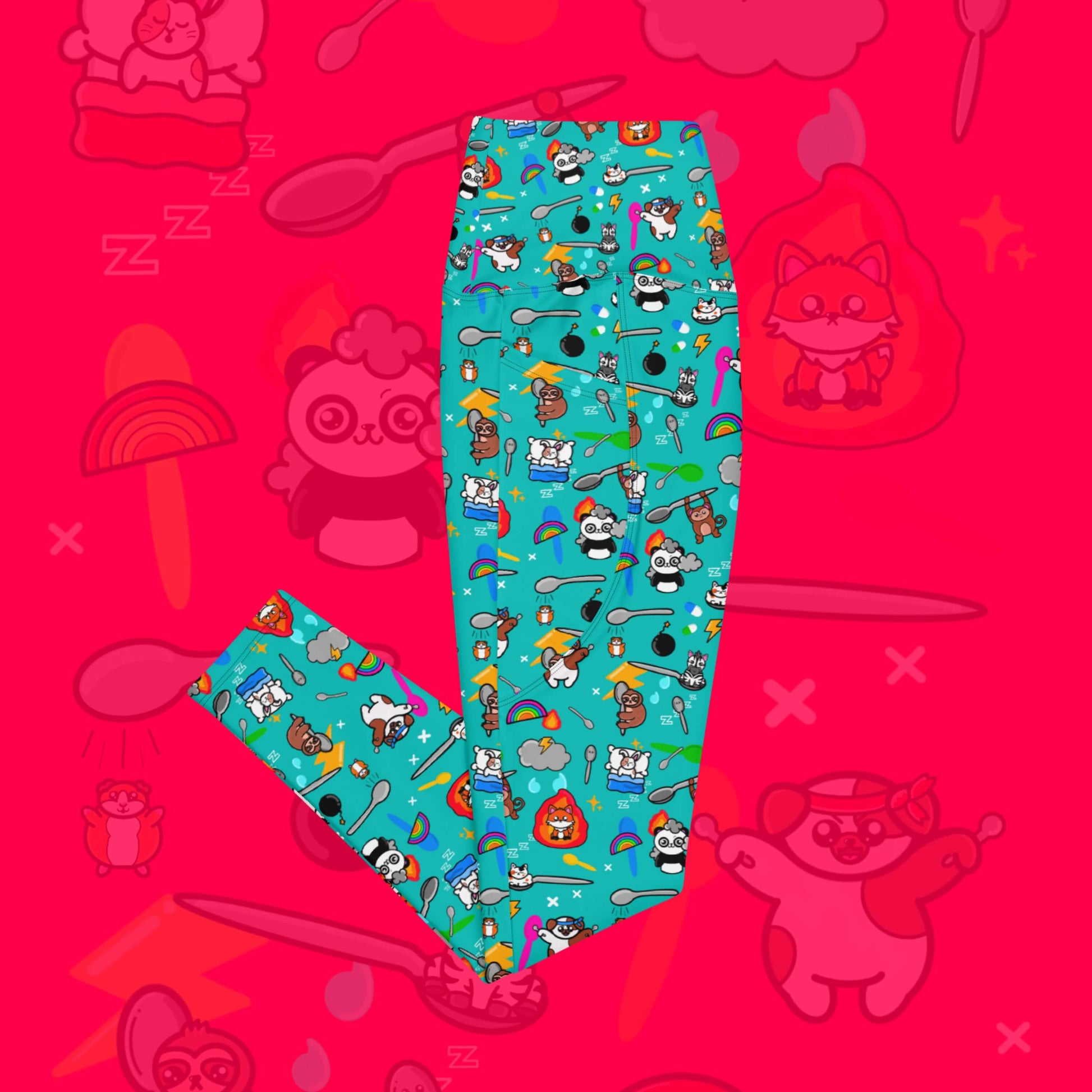 The Spoonie Leggings with Pockets on a red background with a faded version of the print in the background. The blue leggings feature various invisible illness themed animals, rainbows, spoons, sparkles, flames, pills and lightning bolts. Raising awareness for hidden disabilities.