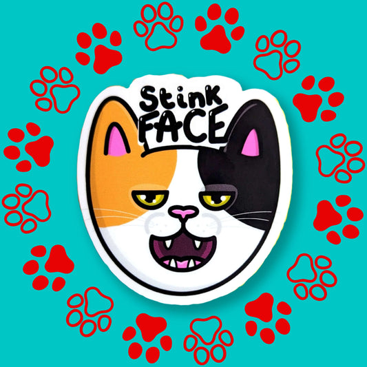 The Stink Face Cat Sticker on a red and blue paw print background. The orange and black cat head sticker is smiling with a smug look on its face and black text above reading 'stink face'. 