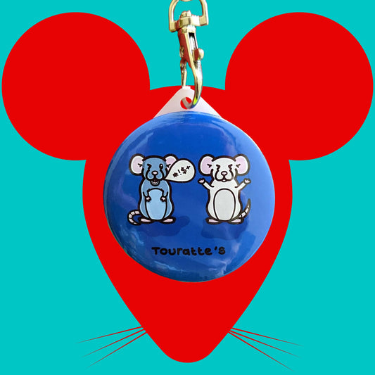 The Touratte's Rat Keyring - Tourette's Syndrome on a red and blue background. The silver lobster clip plastic blue circular keyring has two rats on it, one is grey swearing with a speech bubble and one is white with its eyes shut, across the bottom reads 'touratte's'. The hand drawn design is raising awareness for Tourette's syndrome and tics.