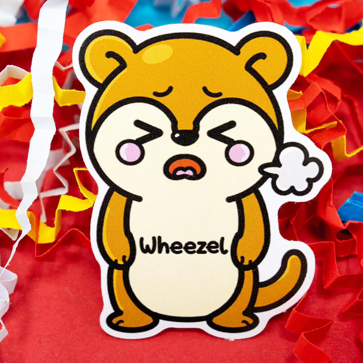 A cute brown cartoon weasel called Wheezel, shown with a puff of air to symbolise wheezing. Surrounded by colourful red, yellow and white confetti, this adorable design by Innabox gently raises awareness for asthma and breathing difficulties. Gloss vinyl, waterproof and approximately 5 cm tall, this disability-inspired sticker spreads empathy and understanding through humour.