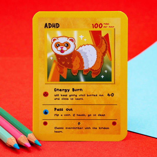Close-up of the ADHD Neurodivergent Collectable Trading Card by Innabox, featuring a cute ferret-style creature with text describing ADHD traits like “Energy Burn” and “Pass out.” Created to support and uplift those with hidden disabilities and chronic illnesses.