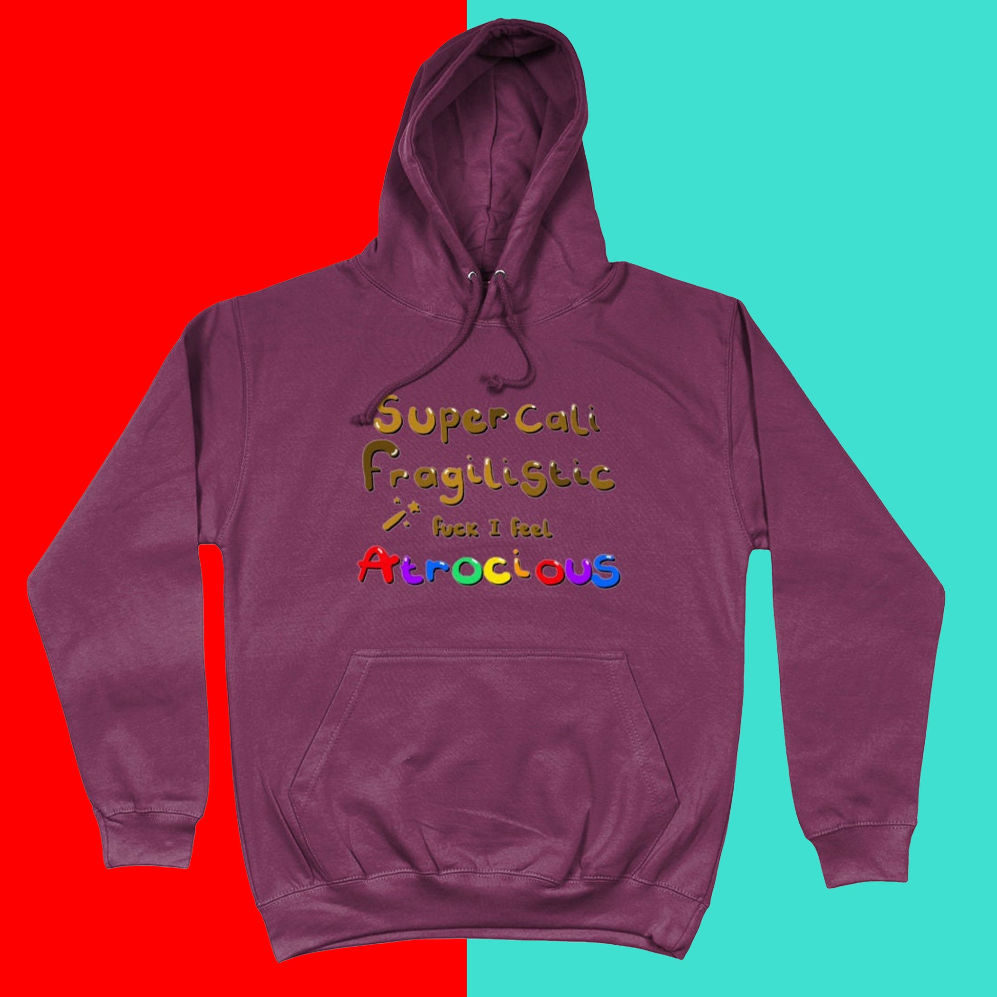 I Feel Atrocious Hoodie on a blue and red background. The plum coloured hoodie has gold text on it that says 'supercali fragilistic f*** I feel' and then 'atrocious' in rainbow coloured text. Design to raise awareness for chronic illness 
