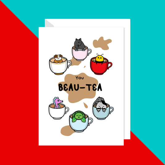 The You Beauty Beau-Tea Valentines Card on a red and blue background with a white envelope. The white a6 greeting card features various animals (guinea pig, tapir, bumble bee, sea horse, turtle and anteater) in cups of tea, in the middle is a big brown tea stain with black text reading 'you beau-tea'.