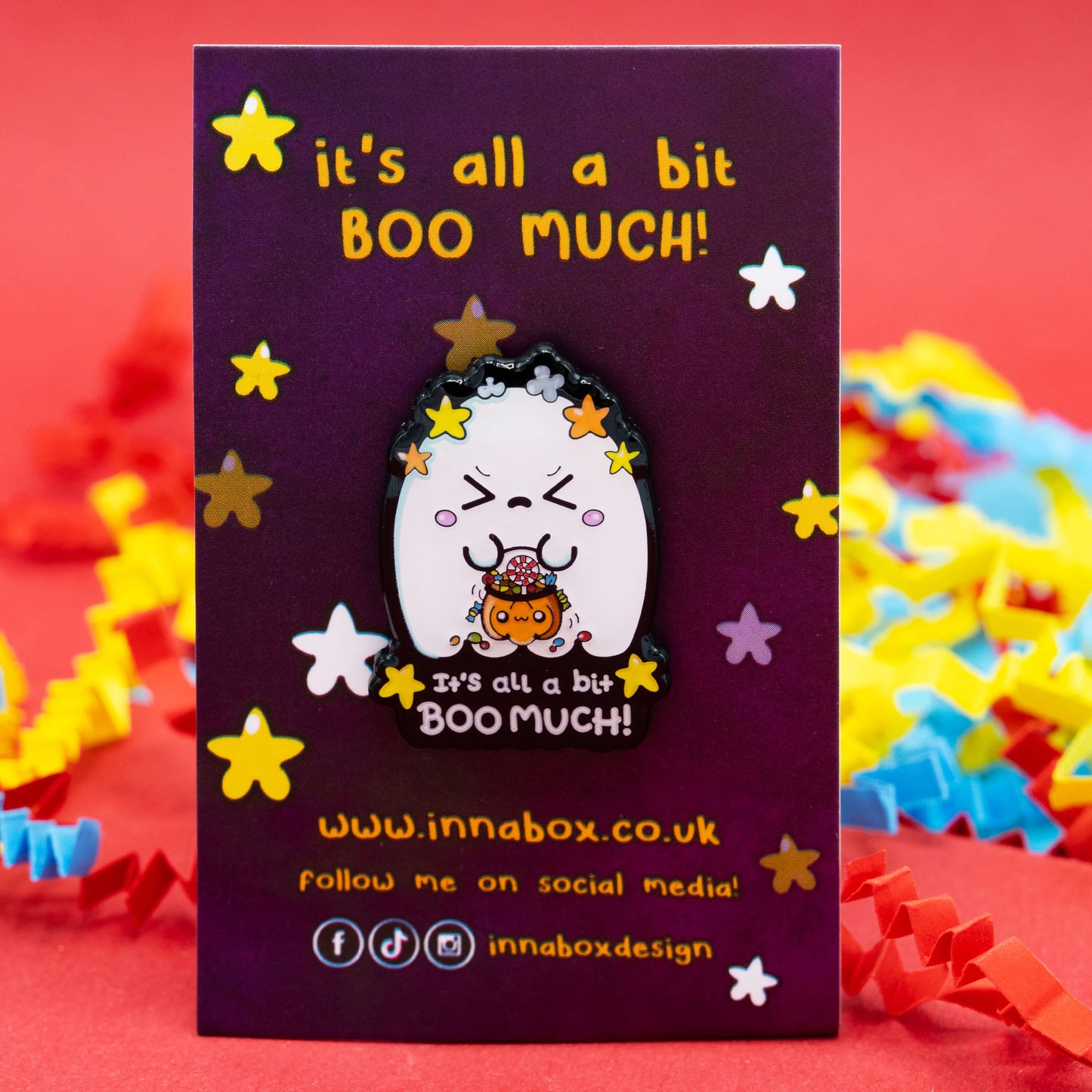 Close-up of the Innabox “It’s All A Bit Boo Much!” Halloween ghost enamel pin on its purple backing card with colourful confetti in the background. A caring gift for spoonies, neurodivergent friends, or anyone feeling overwhelmed.