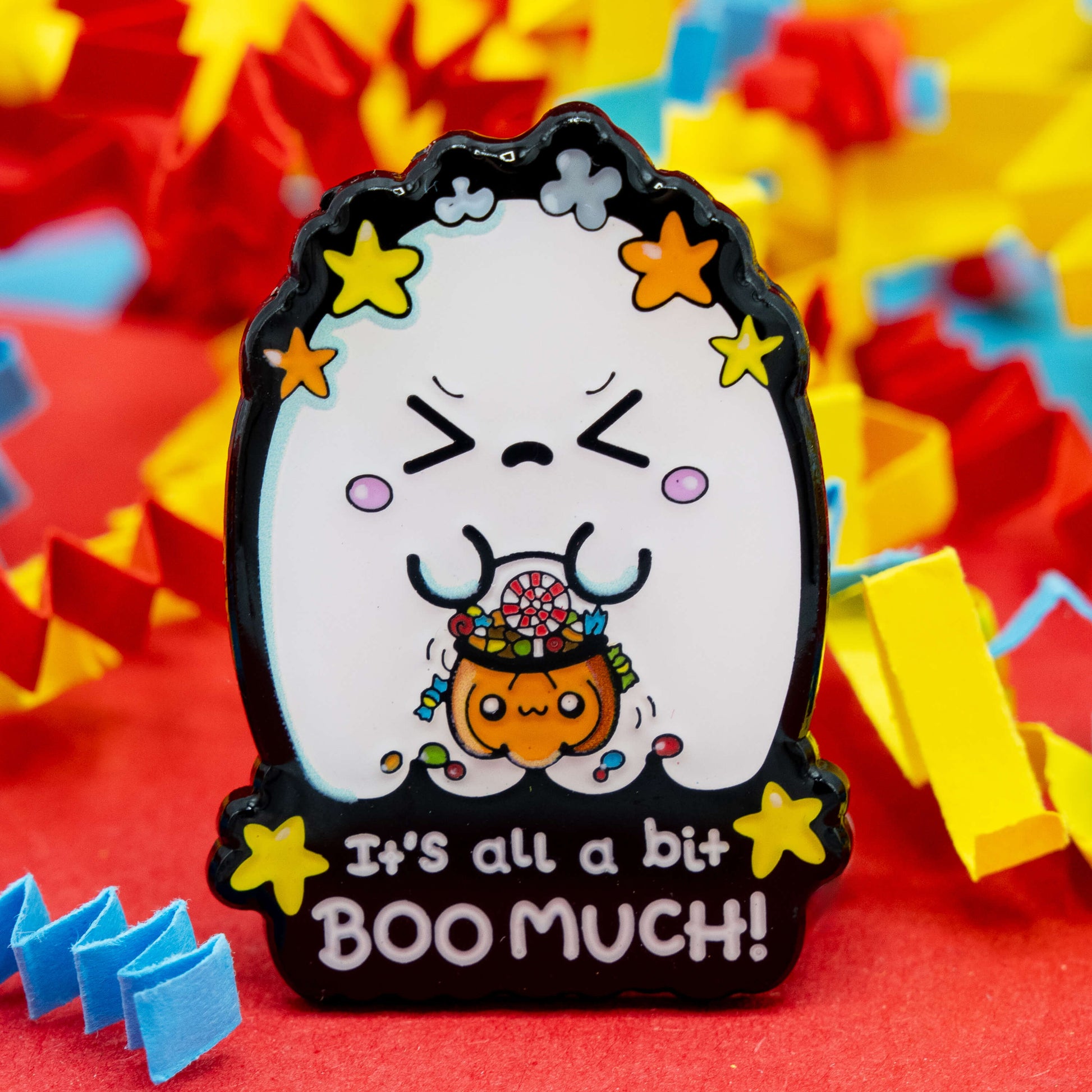 Detailed view of the Innabox “It’s All A Bit Boo Much!” ghost enamel pin showing a sweet ghost character holding a pumpkin candy bucket. A thoughtful Halloween accessory promoting kindness, visibility, and chronic illness awareness.