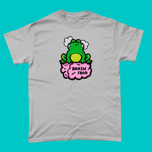 The Brain Frog T-shirt - Brain Fog in grey on a blue background. The t-shirt print is a confused frog with pink blush cheeks and two grey clouds above its head. Its sat on a pink brain with text that reads Brain Frog. The design was created to raise awareness for brain fog.