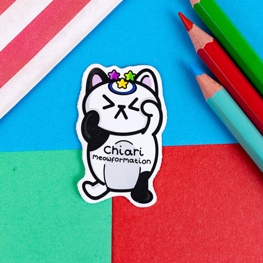 Chiari Meowformation Sticker - Chiari Malformation on a red, blue and green background with colouring pencils and a red stripe candy bag. The sticker is of a black and white cat with a scrunched expression and a dark blue ring on the top of it's head with a purple, yellow and blue star above it. 'Chiari Meowformation' is written across the cat's stomach in black.