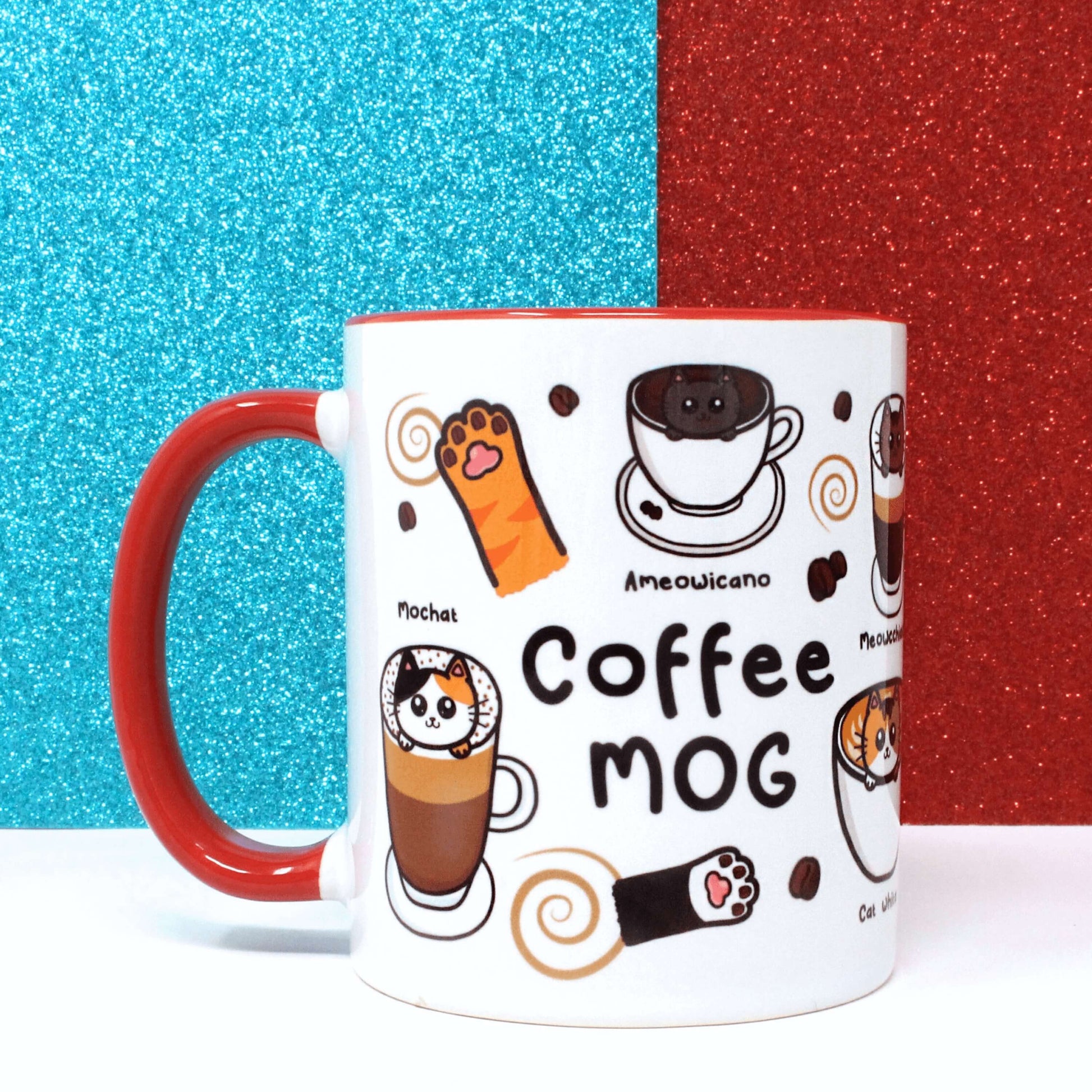  The Coffee Mog Cat Mug on a white table with a red and blue glitter background. The cat themed white coffee mug with red inner and handle is facing right to show black text reading 'coffee mog' and illustrations of cat paw toe coffee beans, mochat (tortoiseshell cat inside a mocha), ameowicano (black cat in a black coffee), coffee beans and brown swirls.