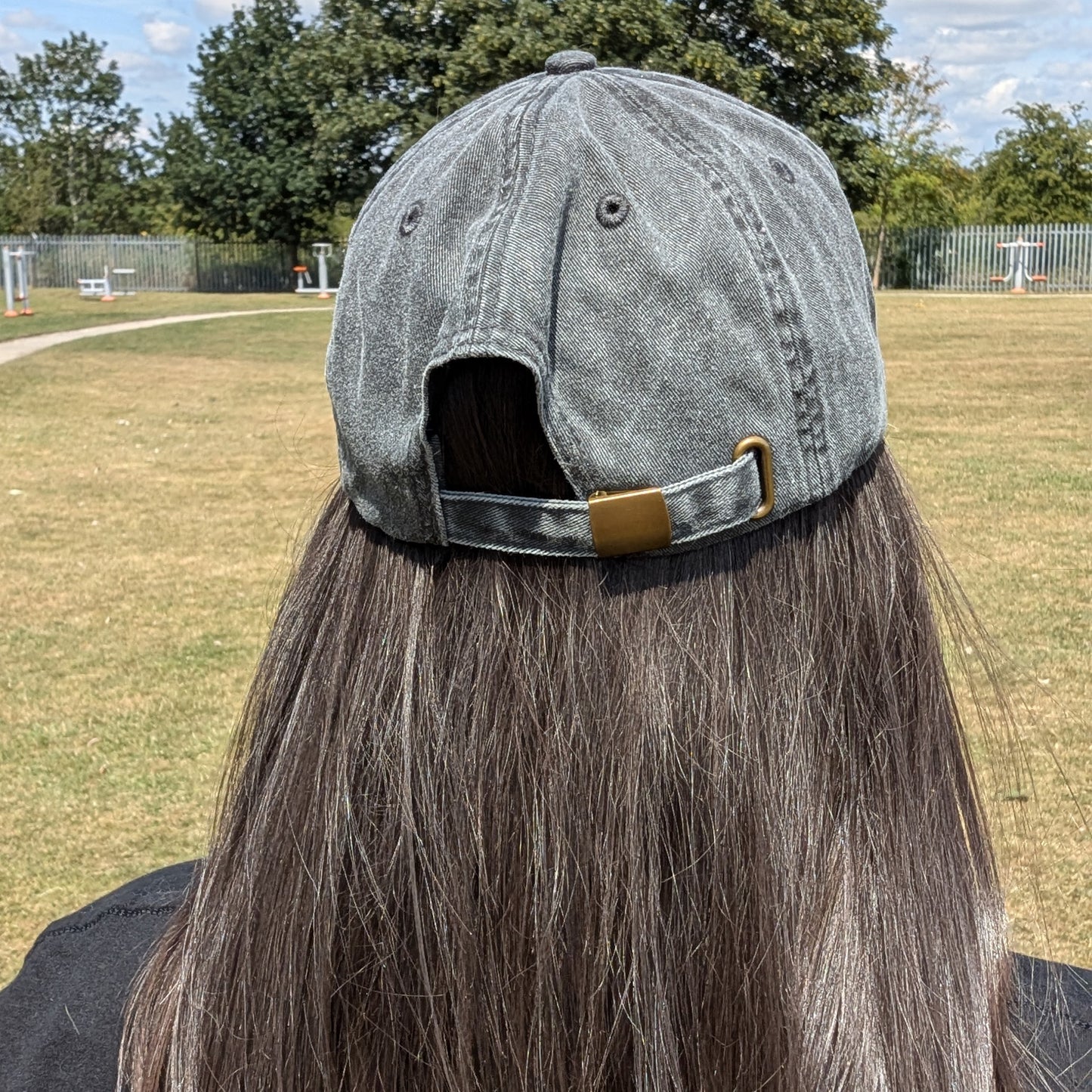Rear view of the Hot and Neuro-Spicy cap worn by a model, showing the adjustable strap with brass effect buckle and soft brushed cotton finish.