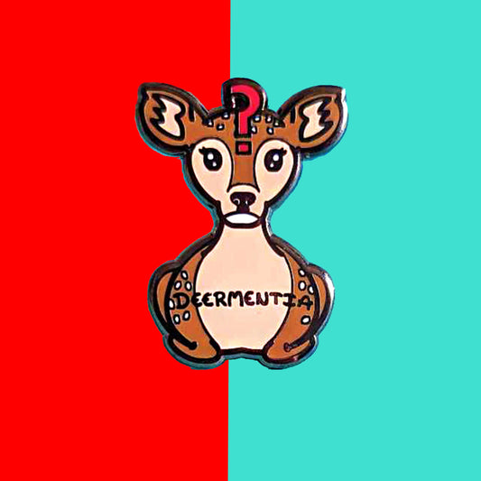 A brown deer shaped enamel pin with long eyelashes, blank expression on it's face and red question mark in the middle of it's forehead. The deer has fluffy ears and white spots and is in a lying down straight on position. 'Deermentia' is written across the light brown tummy in black writing. The pin is shown on a red and blue background.