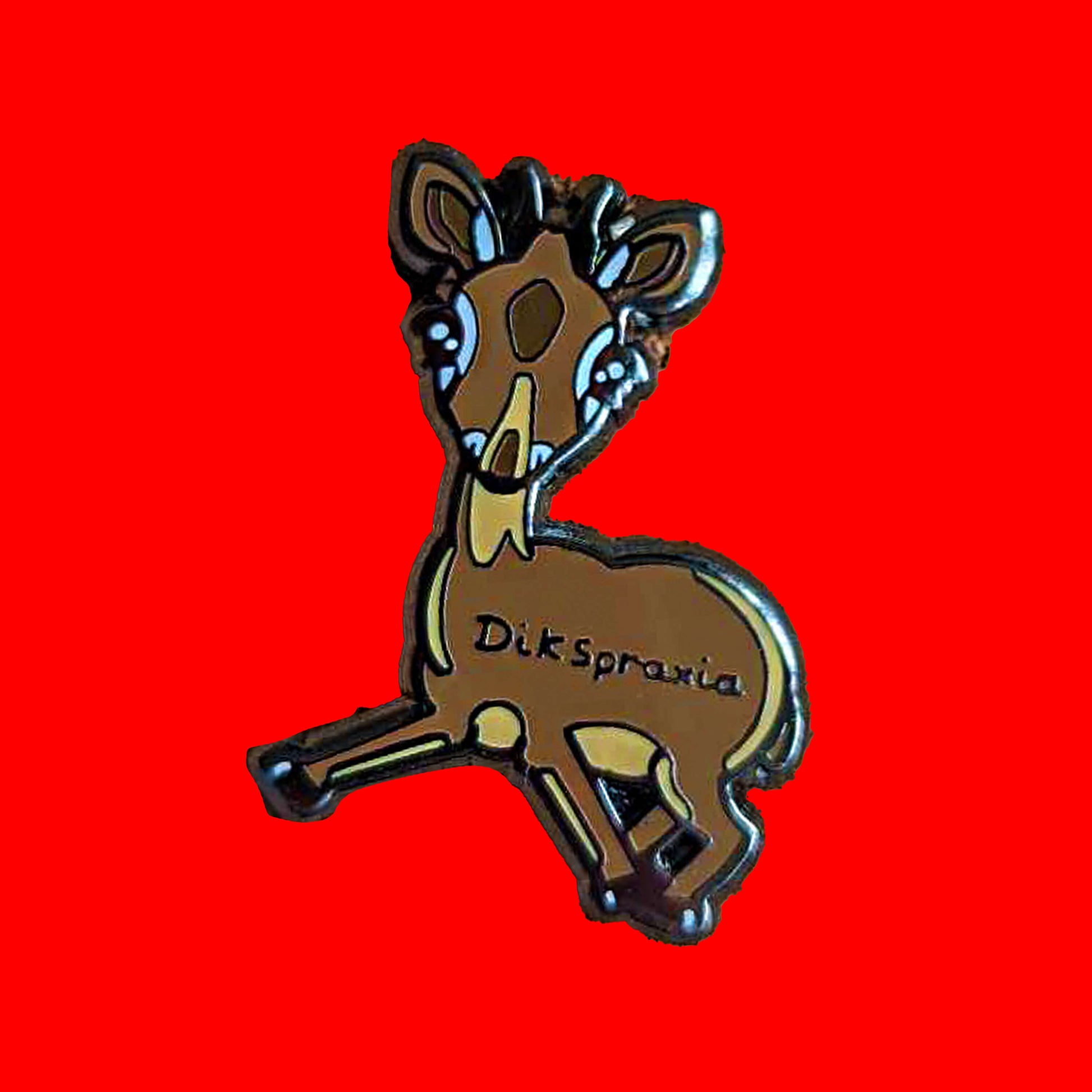 The Dikspraxia Enamel Pin - Dyspraxia on a red background. The brown dik dik antelope shaped enamel pin has its two front legs splayed chaotically with black text reading 'dikspraxia' across its middle. The design is raising awareness for dyspraxia and neurodivergence.