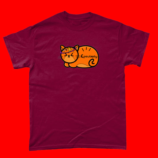 Epawlepsy Tee - Epilepsy. The cardinal red cotton t-shirt is a ginger cat with eyes scrunched closed and symbols to represent a dizzy spell drawn across his head. Epawlepsy is written on the cats stomach. Tee is designed to raise awareness for epilepsy