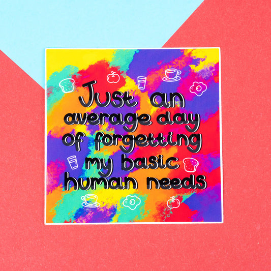 A glossy rainbow square vinyl sticker by Innabox that reads "Just an average day of forgetting my basic human needs" in black outlined text. Surrounded by simple white food and drink icons like toast, a coffee cup, a glass of water, an egg, and an apple. The sticker is displayed on a red and blue background. Perfect for chronic illness and ADHD awareness.
