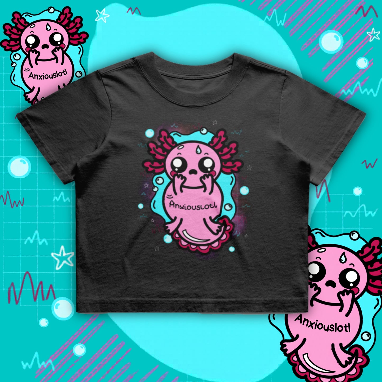 Black oversized axolotl crop tee featuring a cute pink “Anxiouslotl” character with wide eyes and nervous expression, surrounded by teal water shapes and bubbles. Mental health themed design by Innabox, a disability-inclusive brand supporting anxiety and hidden disabilities.
