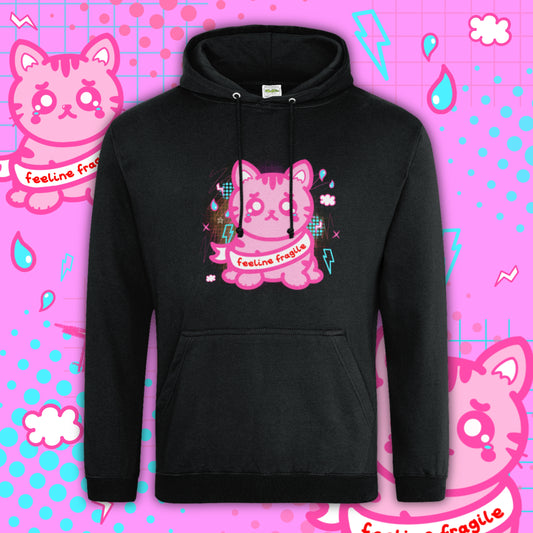 Black hoodie featuring a pink cartoon cat design with the words “feeline fragile” across the front. The cat has a cute, emotional expression with tears and pastel graphic details. This Innabox hoodie is designed to raise awareness of chronic illness and hidden disabilities, combining cosy comfort with meaningful, uplifting artwork.
