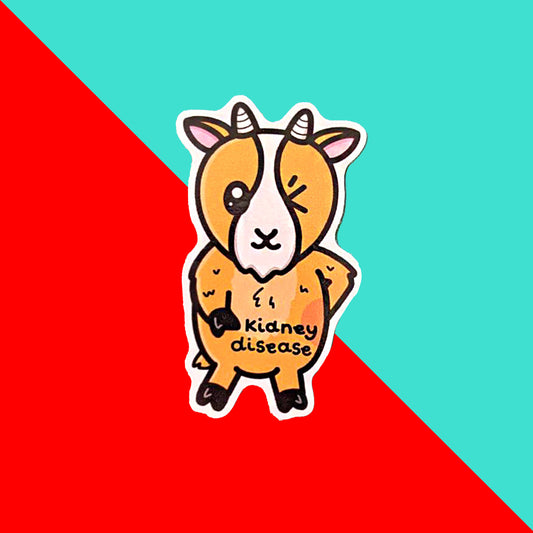 a light brown goat shaped sticker with a white down the centre of it's face and one eye closed shut. The goat has white horns and a fluffy belly. There is a red circle on the side of it's body and 'kidney disease' written on it. The goat is standing on it's back legs. The sticker is shown on a blue background and is next to a red and white striped paper bag.