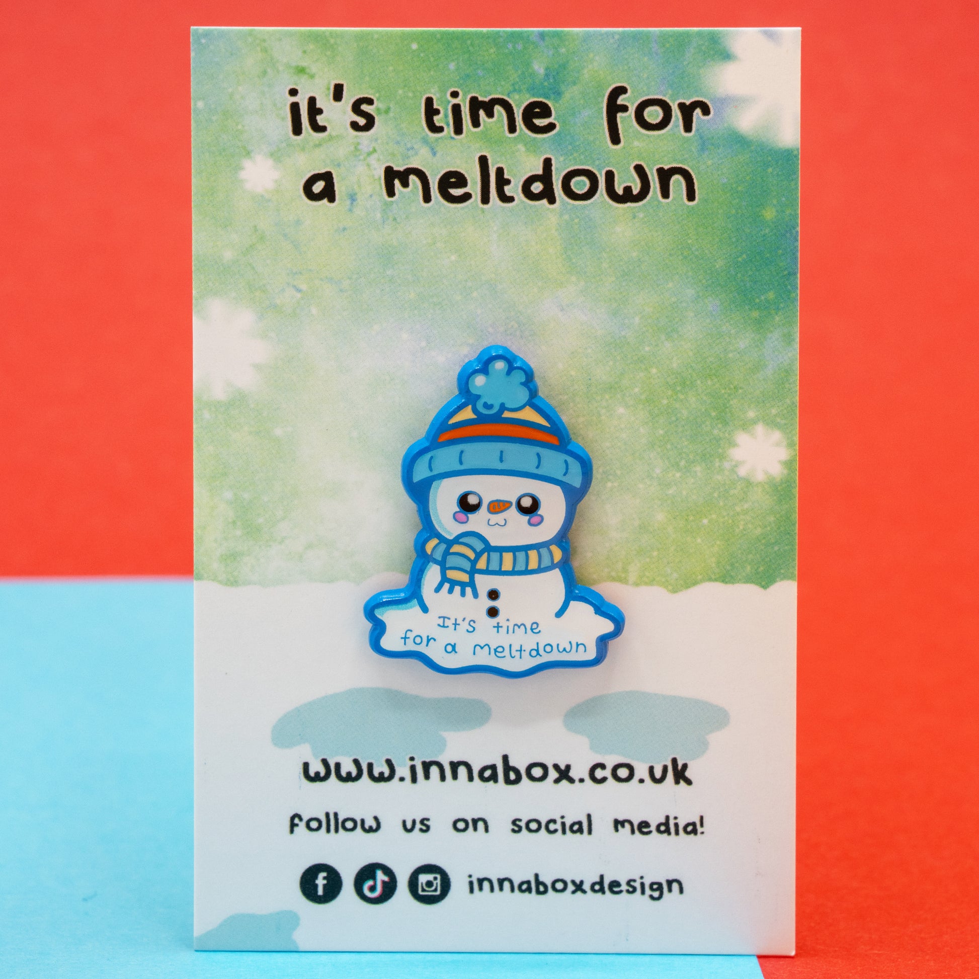 The Innabox ‘It’s Time For A Meltdown’ Snowman Enamel Pin shown sealed in protective packaging on its snowy backing card. Featuring a sweet snowman with a hat and scarf, this disability inspired enamel pin offers gentle encouragement for those facing chronic illness or mental health struggles.