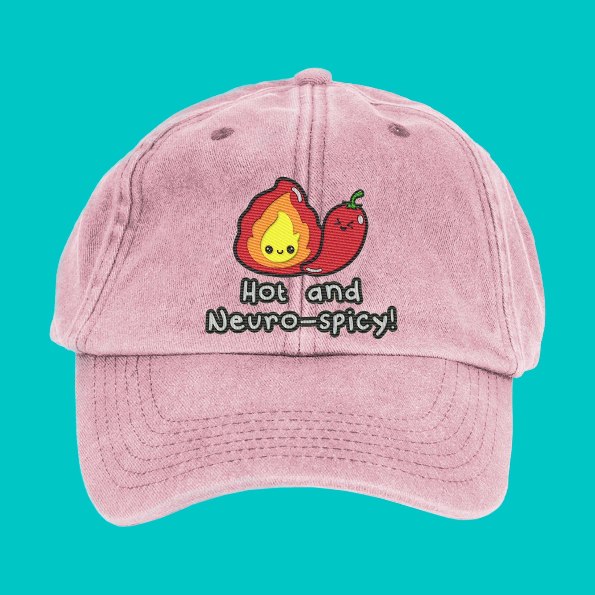 Close-up of a pastel pink cap with cute embroidery of a flame and chilli pepper with the words "Hot and Neuro-spicy!" by Innabox. A fun neurodivergent accessory for people with hidden disabilities.