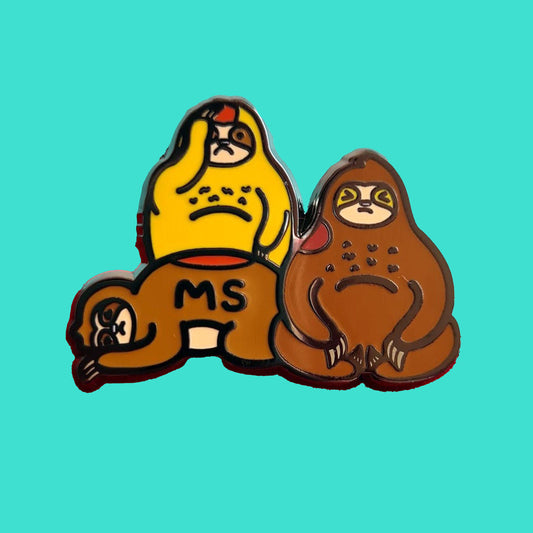 The Multiple Slowrosis Sloth Enamel Pin - Multiple Sclerosis / MS on a blue background. The pin of three sad sloths, two brown and one yellow, with red patches all over their body. Across one in black text reads 'MS'. The hand drawn design is raising awareness for Multiple Sclerosis / MS.