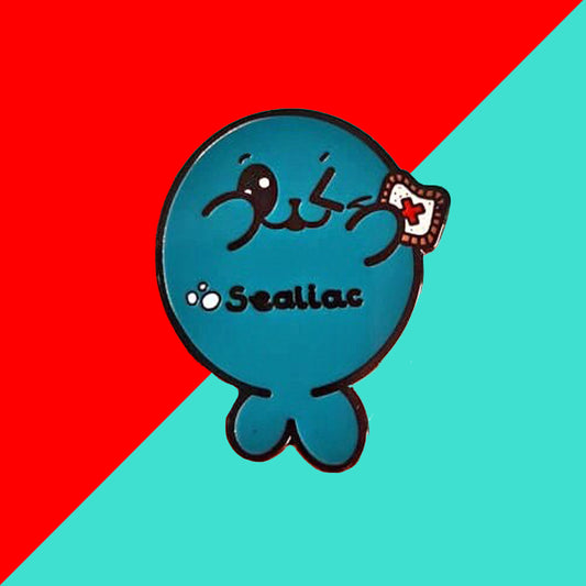 The Sealiac Seal Enamel Pin - Coeliac Disease on a red and blue background. A blue winking smiling seal holding up a piece of toast with a red cross, across its belly in black text reads 'sealiac'. The hand drawn design is raising awareness for coeliac disease.
