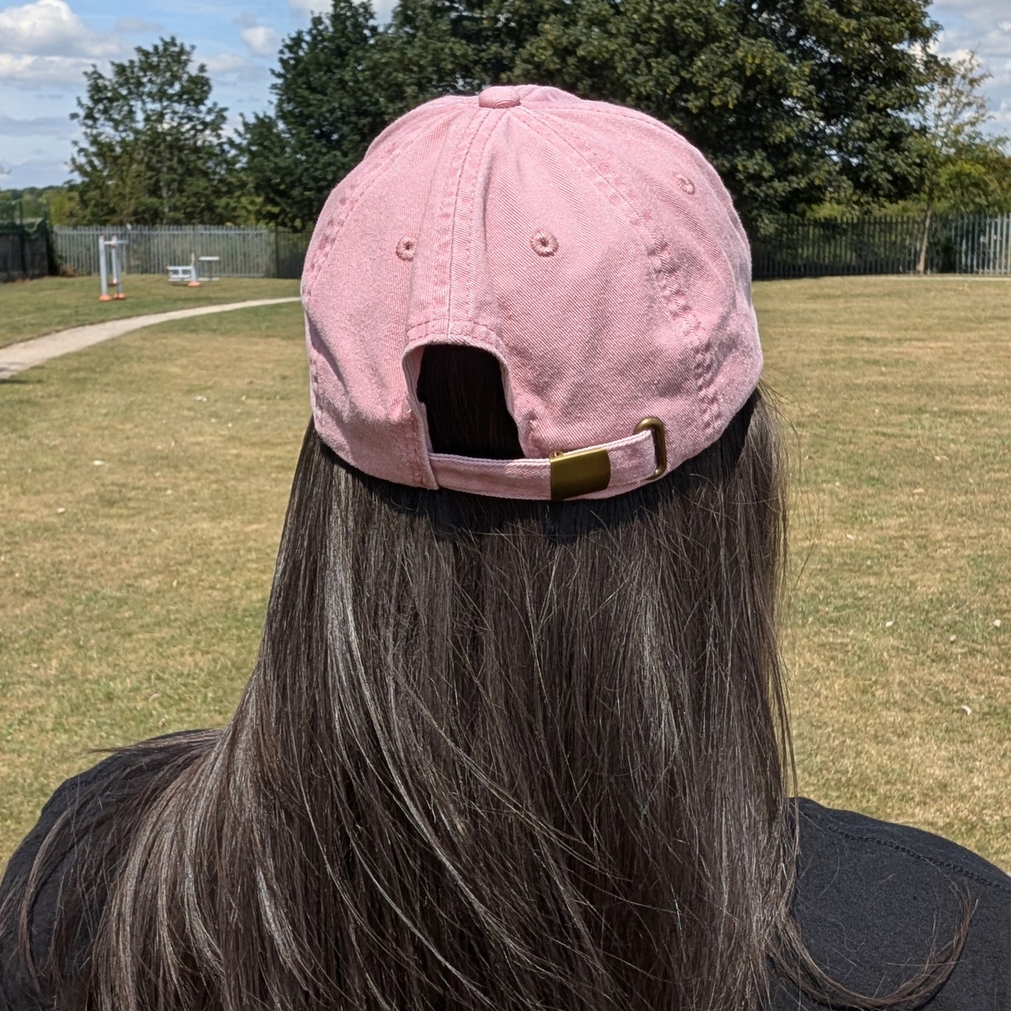 Back view of a person wearing the Hot and Neuro-Spicy cap by Innabox, showing the adjustable brass-effect buckle and soft vintage-style cotton finish.