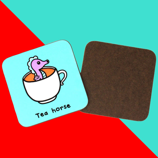 Tea Horse Coaster - Sea Horse shown a red and blue background. The aqua blue wooden coaster has an illustration of a purple and blue seahorse inside a white mug. 'Tea horse' is written in black text underneath. 