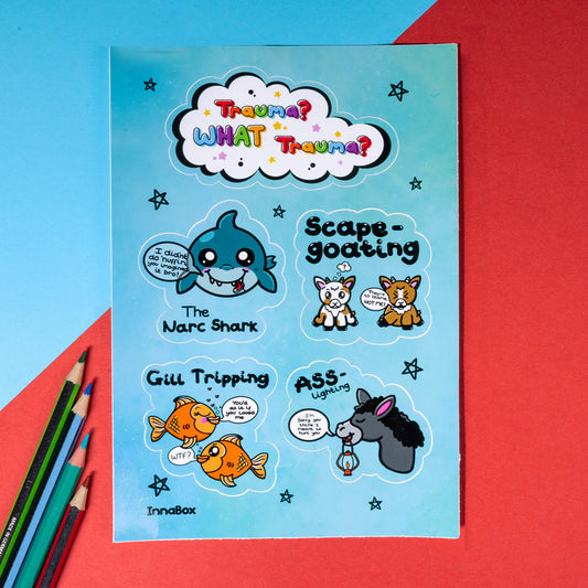 The Trauma? What Trauma? Sticker Sheet - A6 Sticker Sheet on a red and blue background with colouring pencils. The vinyl sticker sheet features 5 different designs based on types of trauma. There's a white cloud with rainbow bubble writing reading 'trauma? what trauma?', the narc shark - a smiling shark, scape-goating - two goats, Gill Tripping - two goldfish and Ass-Lighting - a donkey holding a lantern.